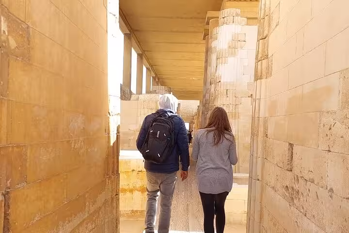 Couple walking through Saqqara temple corridor on a private 3-day Cairo Giza Alexandria pyramids tour