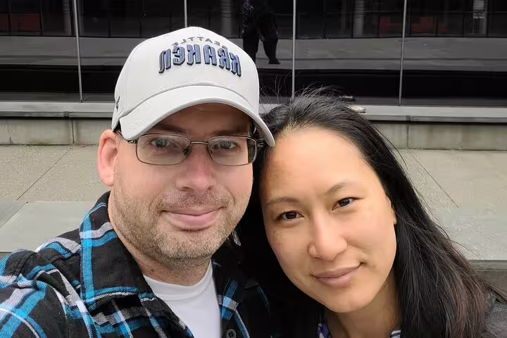 Couple smiling together on a Seattle walking tour outdoors near a modern building