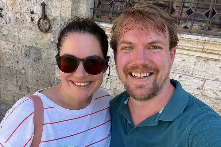 Couple smiling during a self-guided walking tour in medieval Siena, Italy