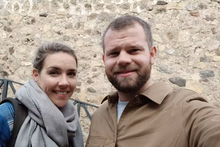 Couple smiling during self-guided walking tour at ancient Pompeii stone ruins