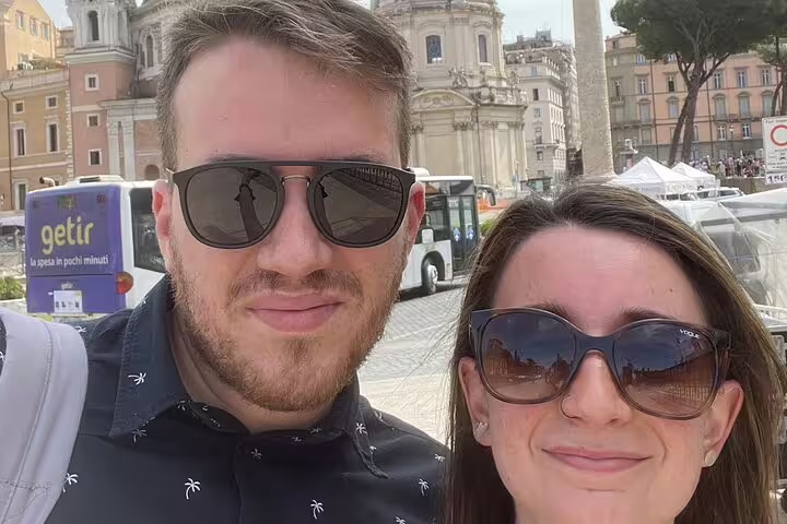 Couple taking a selfie in Rome with ancient church and city buildings in background
