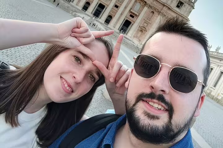 Couple taking a selfie in Rome with a historic baroque building in the background