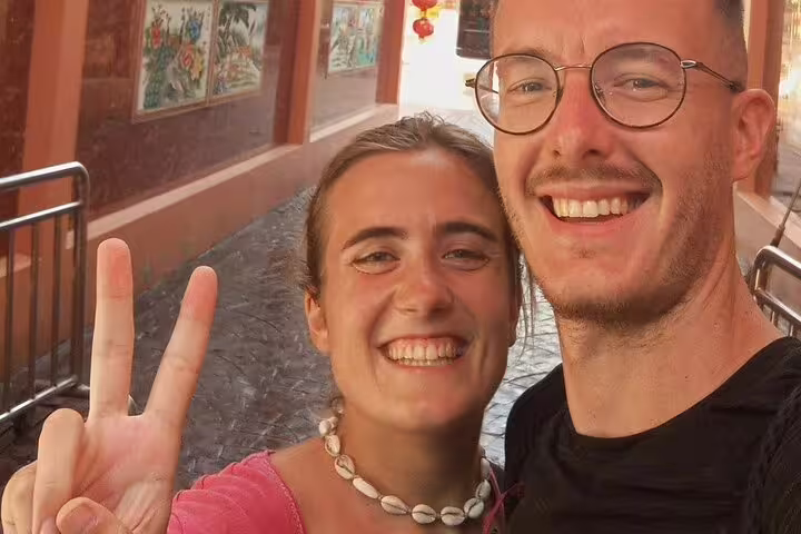 Smiling couple taking selfie in Bangkok Chinatown street with red lanterns in background