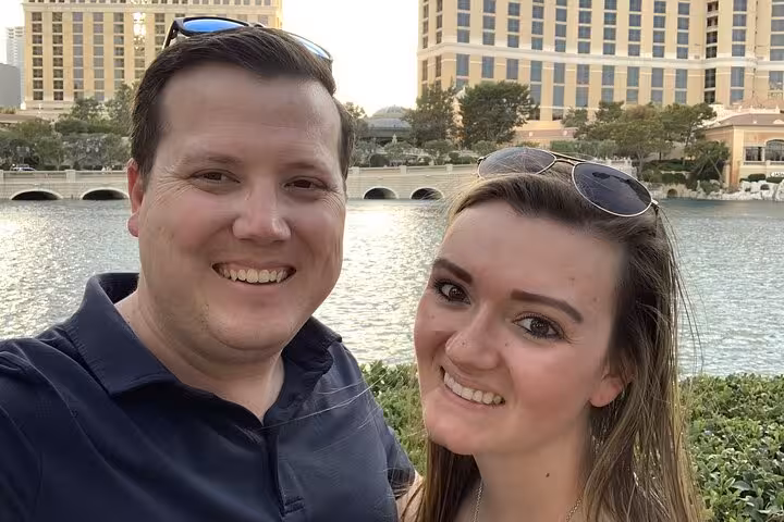 Smiling couple taking a selfie in front of the Bellagio fountains on the Las Vegas Strip