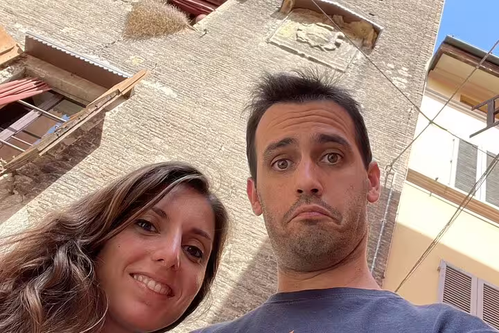Couple taking a selfie in front of a historic stone building in Bologna