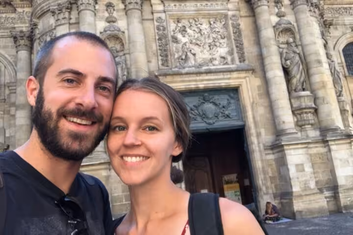 Couple smiling in selfie in front of ornate Bordeaux cathedral facade on walking tour