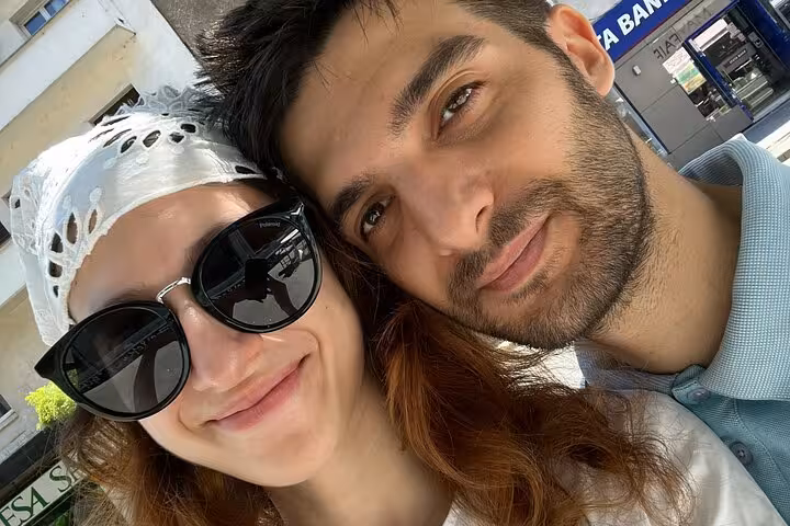 Couple taking a selfie outdoors near a bank in Bucharest city center