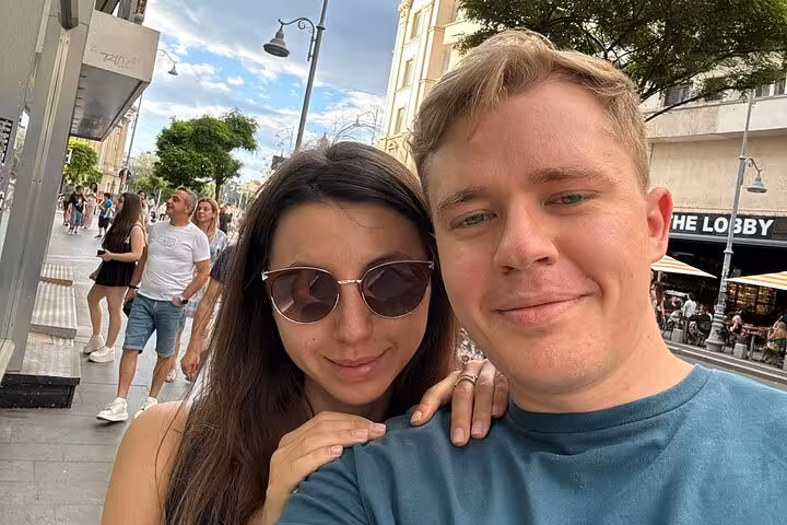 Couple taking selfie on Bucharest pedestrian street during communism walking tour