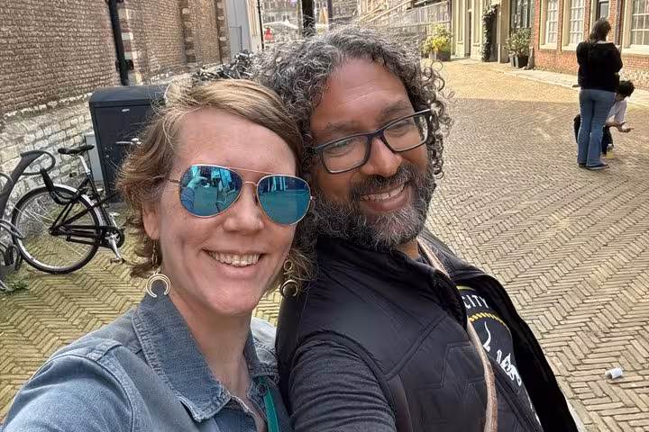 Smiling couple taking a selfie on a cobblestone street in Delft during a walking tour
