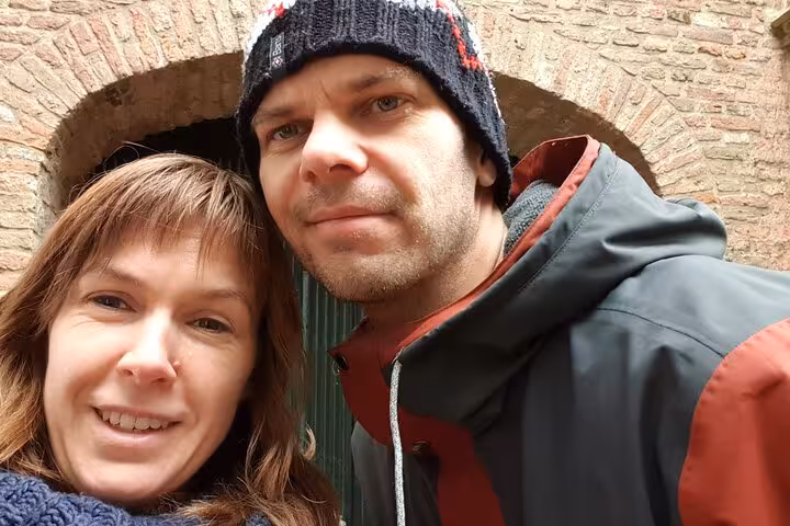 Couple smiling during self-guided walking tour in Delft historic brick archway