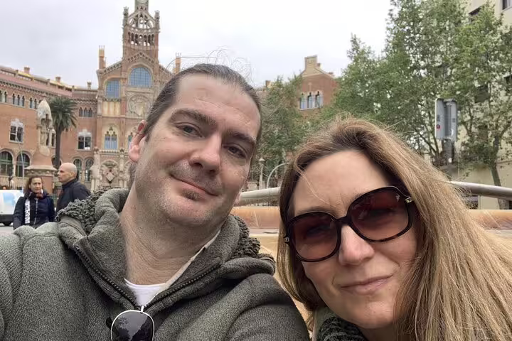 Couple taking selfie in front of ornate Barcelona building during Gaudi walking tour