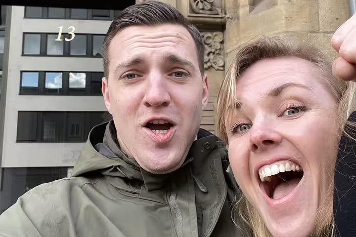 Two excited visitors taking a selfie outside a historic building in Cologne during a haunted walking tour