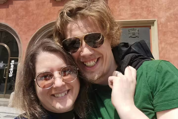Smiling couple taking a selfie in Prague streets during a walking tour