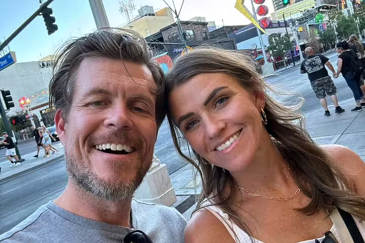 Smiling couple taking a selfie on a Las Vegas street during a self-guided walking tour