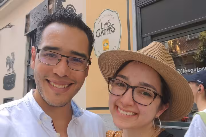 Smiling couple posing for selfie outside Los Gatos bar in Madrid during daytime