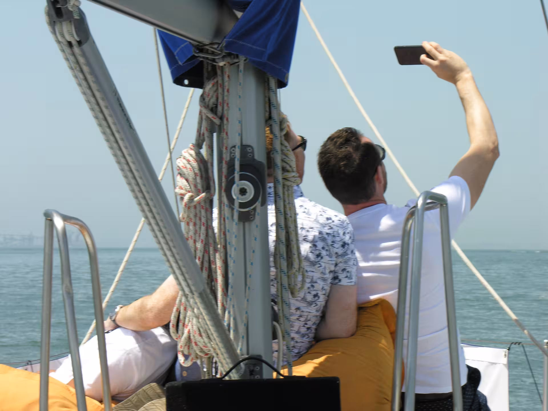 Couple taking a selfie on a luxury sailboat in Lisbon on the Tagus River, romantic private sailing tour
