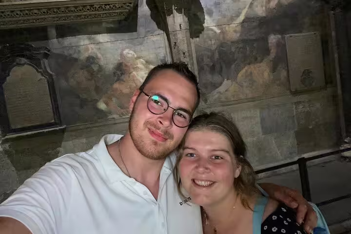 Couple taking selfie inside medieval Vienna church with historic frescoes and stone plaques