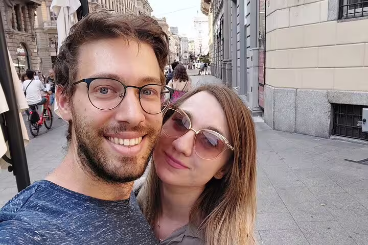 Couple taking a selfie on a busy Milan street during a self-guided walking tour