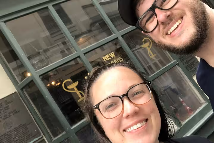 Smiling couple taking selfie outside New Orleans French Quarter storefront