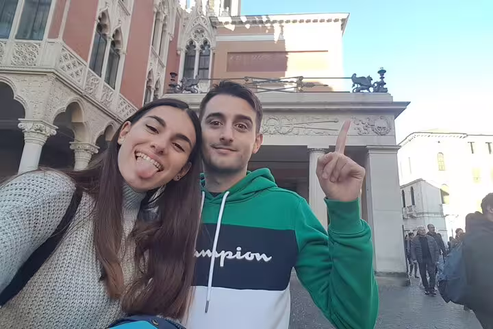 Smiling couple taking selfie in front of historic Padua architecture during walking tour