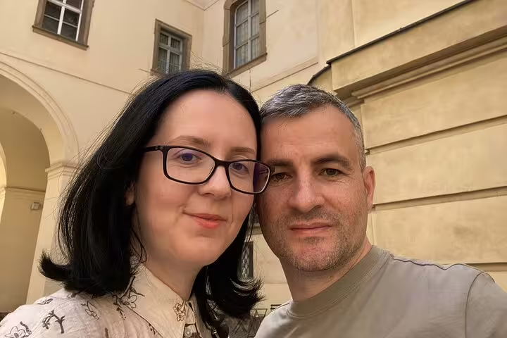 Couple taking selfie in Prague Old Town courtyard with historic building facade