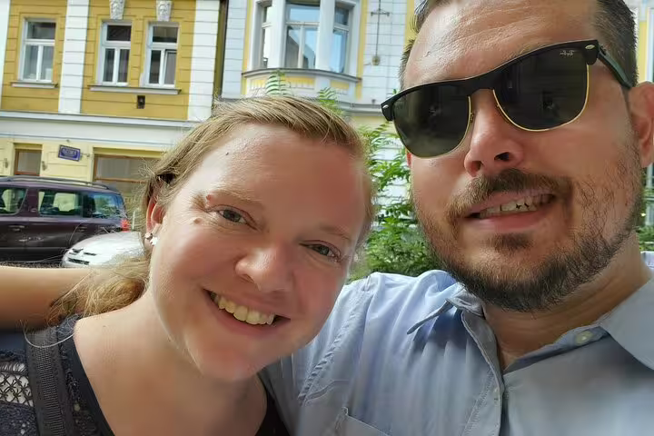 Smiling couple taking a selfie on a sunny street in Prague Old Town