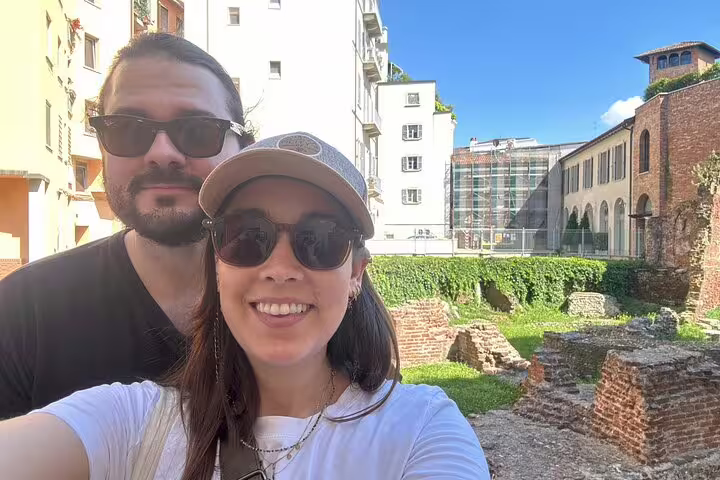 Couple taking a selfie in front of ancient Roman ruins in Milan on a sunny day