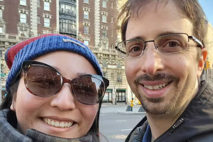 Smiling couple taking a selfie on a NYC street during a romantic walking tour