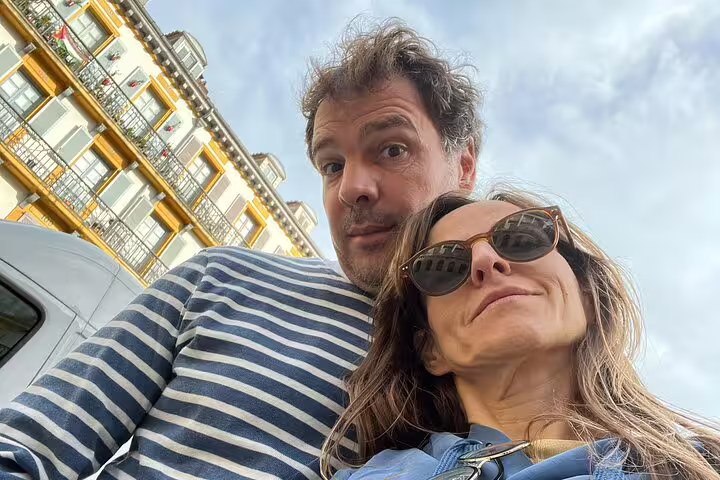 Couple taking a selfie in San Sebastian Old Town with colorful historic building in background
