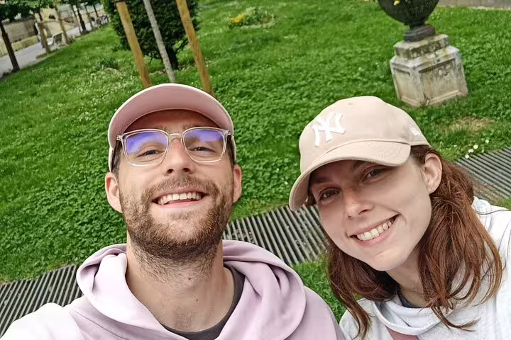 Smiling couple taking a selfie outdoors in a green park during a walking tour