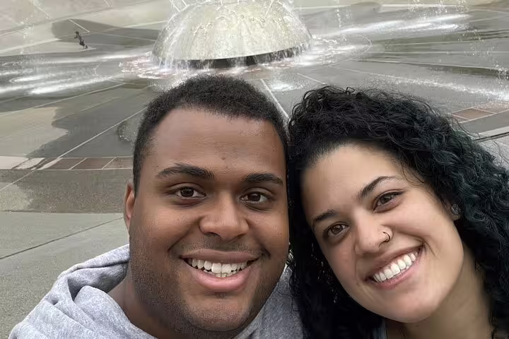 Smiling couple taking selfie in front of Seattle fountain during walking tour