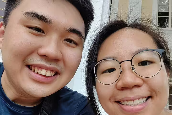 Two smiling tourists taking a selfie during a walking tour in Singapore
