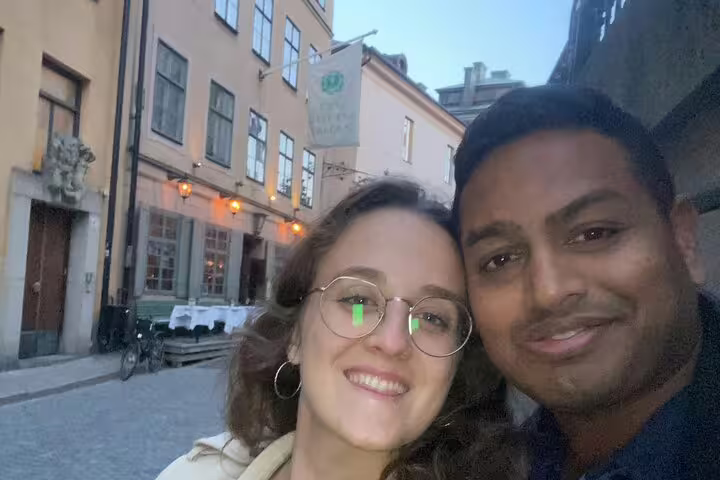 Couple smiling on a cobblestone street in Stockholm Old Town at dusk