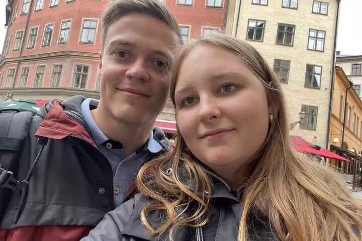 Couple taking a selfie in Stockholm Old Town with colorful historic buildings in the background