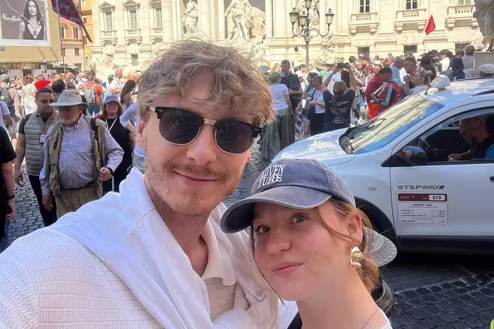 Couple taking selfie at Trevi Fountain in Rome during walking tour