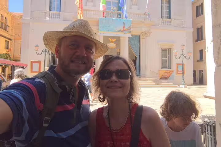 Couple taking a selfie during a self-guided walking tour in Venice, Italy with historic buildings behind them