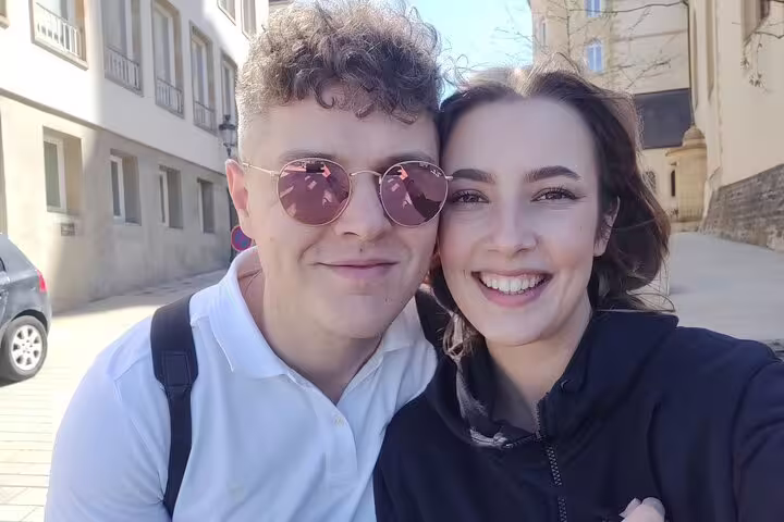 Smiling couple taking a selfie on a sunny street in Luxembourg City