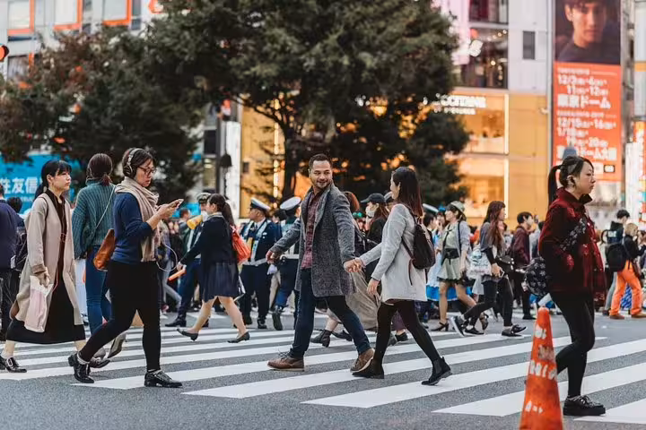 Couple crossing Shibuya Scramble in Tokyo during private photo tour, candid street photography with local guide