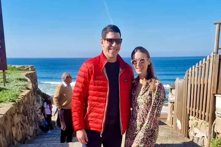 Couple enjoying a sunny day with ocean views during a private Sintra and Cascais hidden gems tour with wine tasting.
