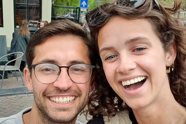 Happy couple smiling during Amsterdam city walking tour exploration
