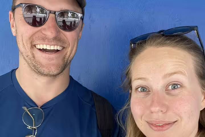Smiling couple posing against blue wall at Toronto's Distillery District