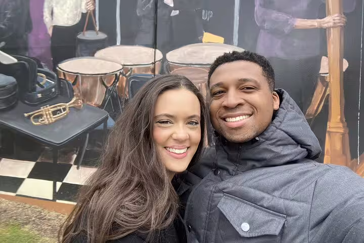 Smiling couple posing together in front of a colorful music mural in Downtown Atlanta