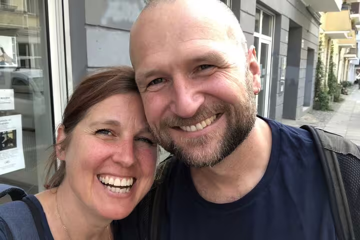 Smiling couple cheek to cheek on an East Berlin street during a self-guided tour