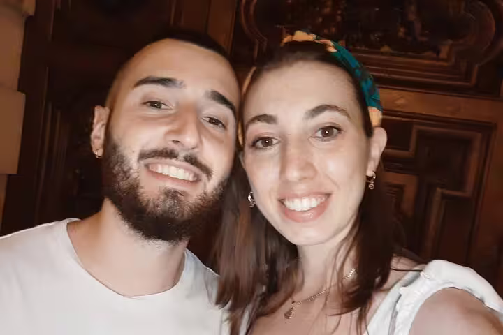Smiling couple posing together indoors near ornate wooden decor in Turin