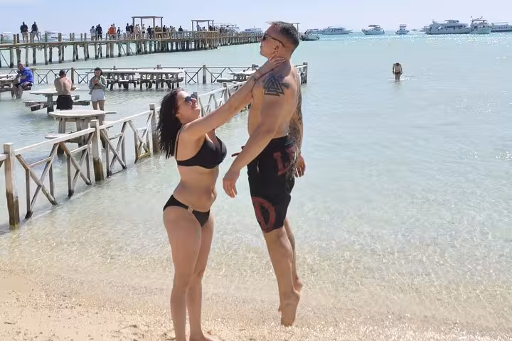 Couple enjoying shallow turquoise water at Orange Bay Hurghada, island day trip with snorkeling and drinks