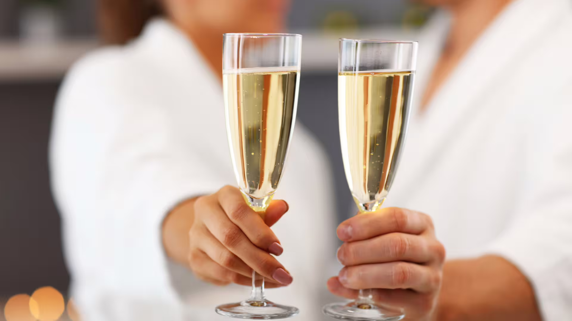 Couple in spa robes toasting with sparkling wine, celebrating a romantic Amalfi Coast getaway with luxury wellness treatments