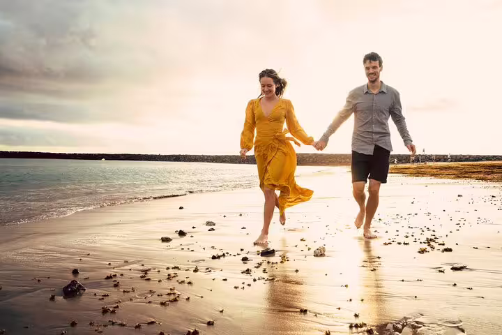 Couple holding hands on Tenerife beach at sunset during private photoshoot with professional photographer