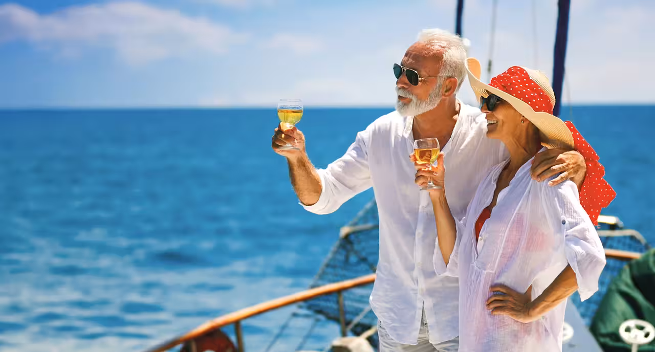 Couple toasting with wine glasses on a guided sunset cruise in Vilamoura enjoying the calm blue sea