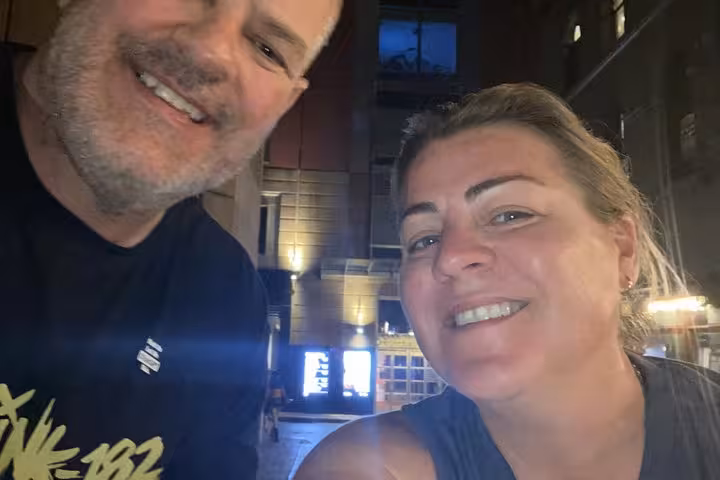 Smiling couple taking a selfie outdoors at night during a Sydney ghost walking tour