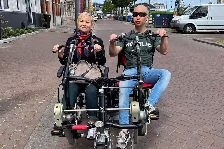 Couple riding a tandem bike in Amsterdam on a guided private bike tour exploring 19th century neighborhoods